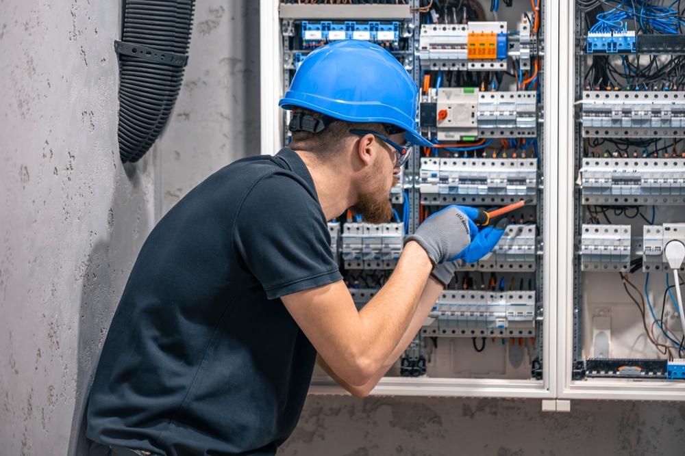 Licensed electrician repairing common electrical problems in a residential home electrical panel
